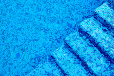 Blue steps under the water in the poolの写真素材
