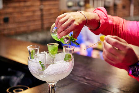 a man pours the cocktail glass at barの写真素材
