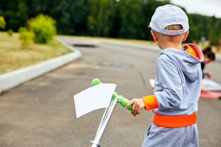 a little boy with a scooter and a white flagの写真素材