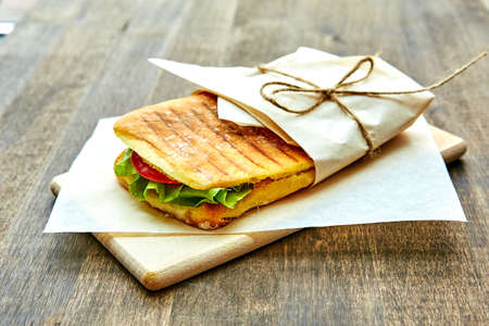 sandwich in an envelope, tied with rope to a wooden tableの写真素材