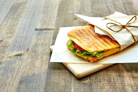 sandwich in an envelope, tied with rope to a wooden tableの写真素材