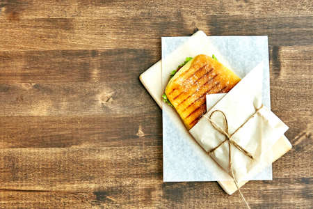 sandwich in an envelope, tied with rope to a wooden tableの写真素材