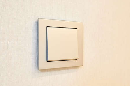 a light switch, a plastic mechanical switch installed on a light gray wall.の写真素材