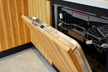 close up of open dishwasher without clean glasses and dishesの写真素材
