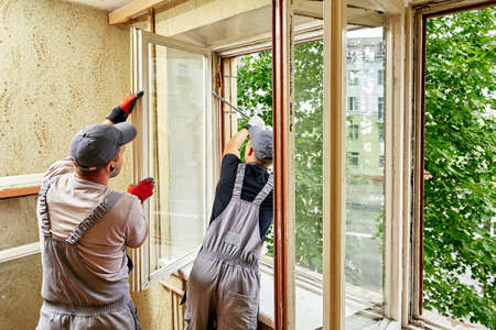 man expands window for repairsの写真素材