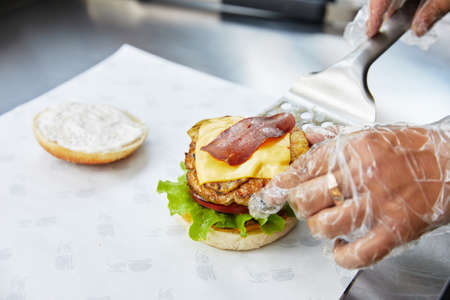 cooking hamburger with great roll, bacon, cheese, cutlet, herbs and onionsの写真素材