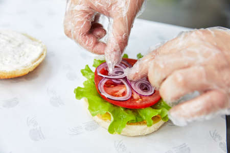 cooking hamburger with great roll, cheese, cutlet, herbs and onionsの写真素材