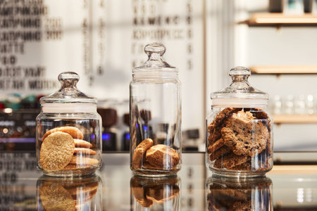 oatmeal cookies in three glass jars, on a glass table