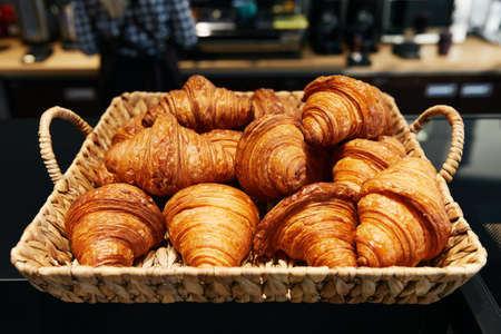 puff croissants folded in a wicker basket, pastry bakery, fresh rollsの写真素材