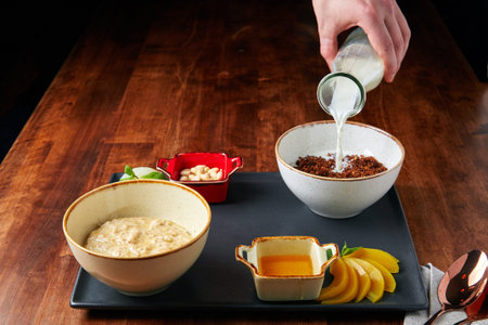 proper food tray, oatmeal and buckwheat, nuts and beans, mango and sauce, on a wooden table with a...