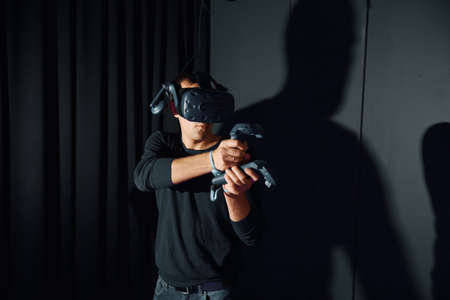 Russia, Moscow, 01.09.2019, men plays with virtual reality glasses, holds a controller in her handsのeditorial素材