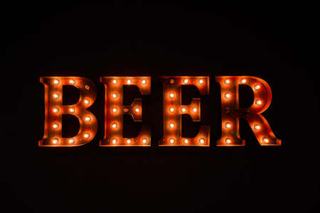 large luminous inscription BEER from light bulbs, in the dark, backgroundの写真素材