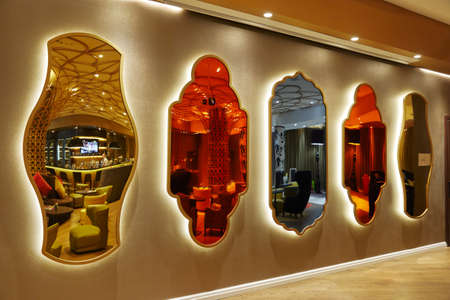mirrors of different shapes and colors hanging on a wall in a row, design, interiorの写真素材