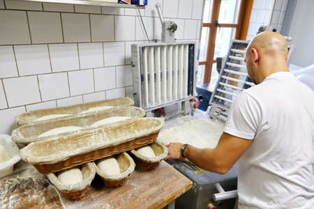 Russia, Moscow,10.06.2019, the cook makes slices of dough and puts in a row in a bowl, pastries, flour productsのeditorial素材