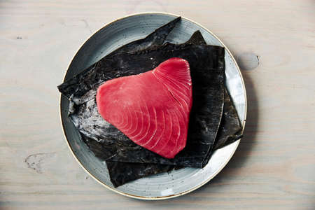 tuna fillet on a plate, on a white wooden backgroundの写真素材