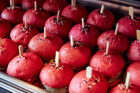 hamburgers with lush red buns are laid out on the windowの写真素材