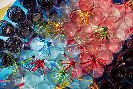 many glass glasses of different colors stand with drinks and are decoratedの写真素材