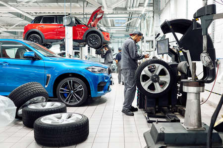 Moscow, Russia, 09.05.2019, a man repairs cars in a car repair shop, many wheels, BMW, tire fittingのeditorial素材