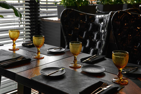 Elegant black table setting: plates, napkin and silverware over black background