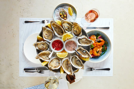Seafood platter with opened oysters with sauce and shrimp