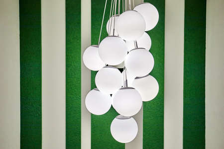 Chandelier in the form of many round plafonds of balls against the background of striped wallpaperの写真素材