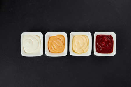 different sauces in small white plates, ketchup, mayonnaise, mustard, garlicの写真素材
