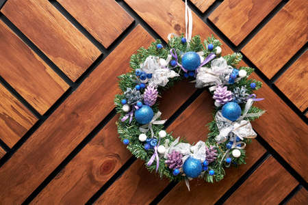 christmas wreath in blue shades hanging on a wall of wooden boardsの写真素材