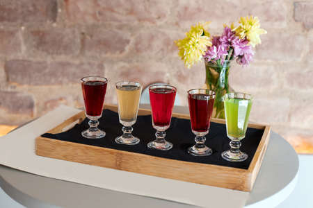 Alcoholic tinctures of different taste and color poured into glassesの写真素材