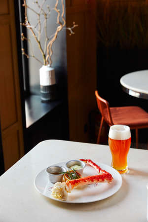 Cooked crab, seafood with sauces, beer, on the table in the restaurantの写真素材