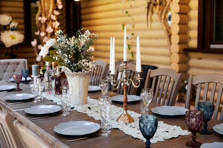 Table setting for a family dinner in a restaurant with candlesの写真素材