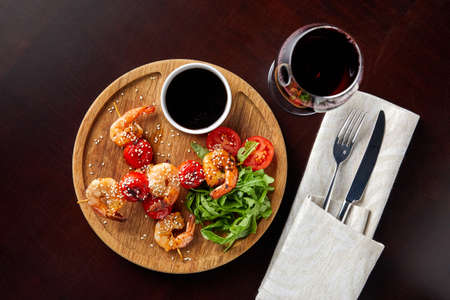 canapes with shrimp and tomato, sprinkled with sesame seeds with arugula, sauce and wine,Skewersの写真素材