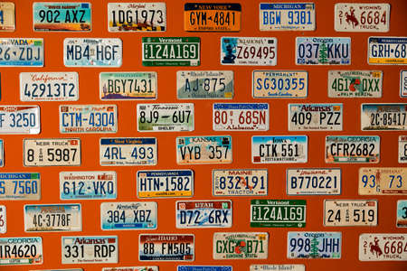 American license plates hang on an orange wallの写真素材