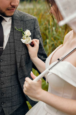 the bride corrects the flower in the grooms buttonhole, weddingの写真素材