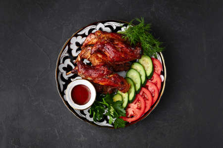 roast Chicken with sliced cucumber and tomato sauce on a black backgroundの写真素材