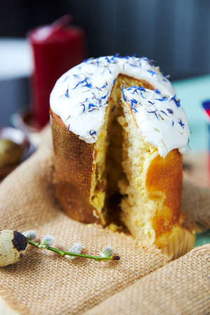Easter cake with white glaze strewn with cornflowers petalsの写真素材