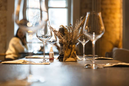 Table in the restaurant on which there are empty glasses and a vase, servingの写真素材