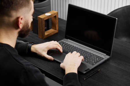 a man works at a laptop on a gray table, a mockupの写真素材