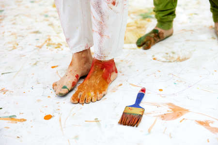 childrens painted feet with paints on the white floor in redの写真素材