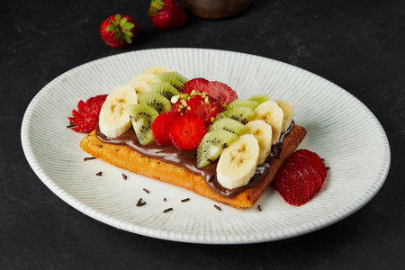 Belgium waffle with fruits and chocolate paste on plateの写真素材