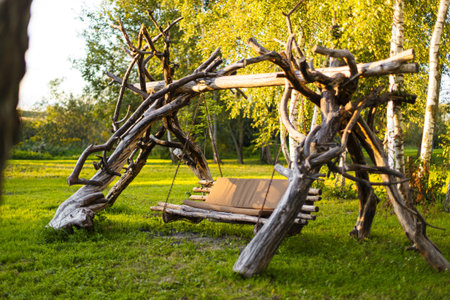 Swinging bench made of natural materials in summer parkの写真素材