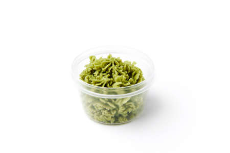 Green hot wasabi condiment in plastic jar isolated on whiteの写真素材