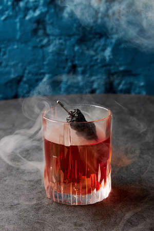 Alcohol cocktail with dry hot pepper in smoke on stone tableの写真素材