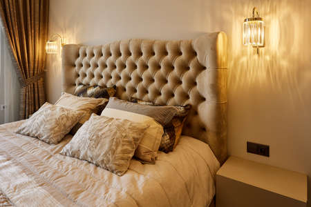 Different pillows and blanket on king size bed in hotel roomの写真素材