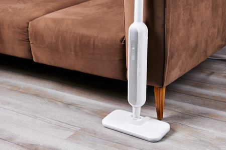 Electric mop to wash floor near sofa in living room closeupの写真素材