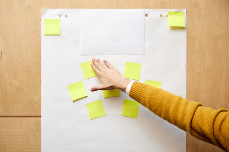 Office worker puts yellow memo stickers on board preparing for working on business project. Employee puts effort in making effective planの写真素材