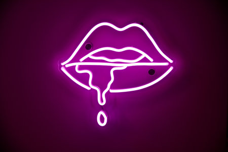 Purple neon sign with leaking saliva from female lips on wall of nightclub. Street wall illuminated by bright neon advertisementの写真素材