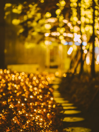 Christmas magic background. Yellow and orange bokeh with night alley