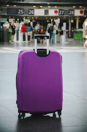 Purple hand luggage in international airport terminalの写真素材