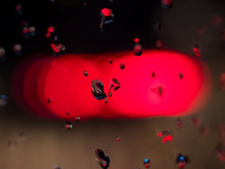 Water drops on glass with red background