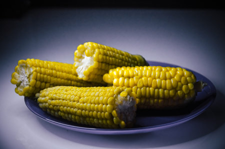 Fresh yellow corn on the purple dishの写真素材